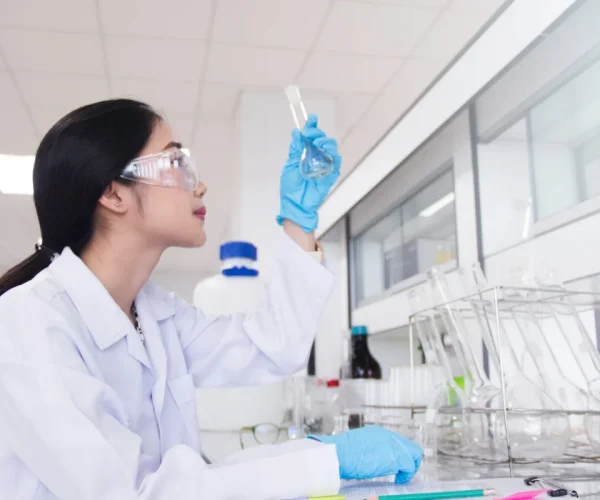 Interior of clean modern white medical or chemical laboratory background.Laboratory scientist working at lab with test tubes and report. Laboratory concept with Asian woman chemist.